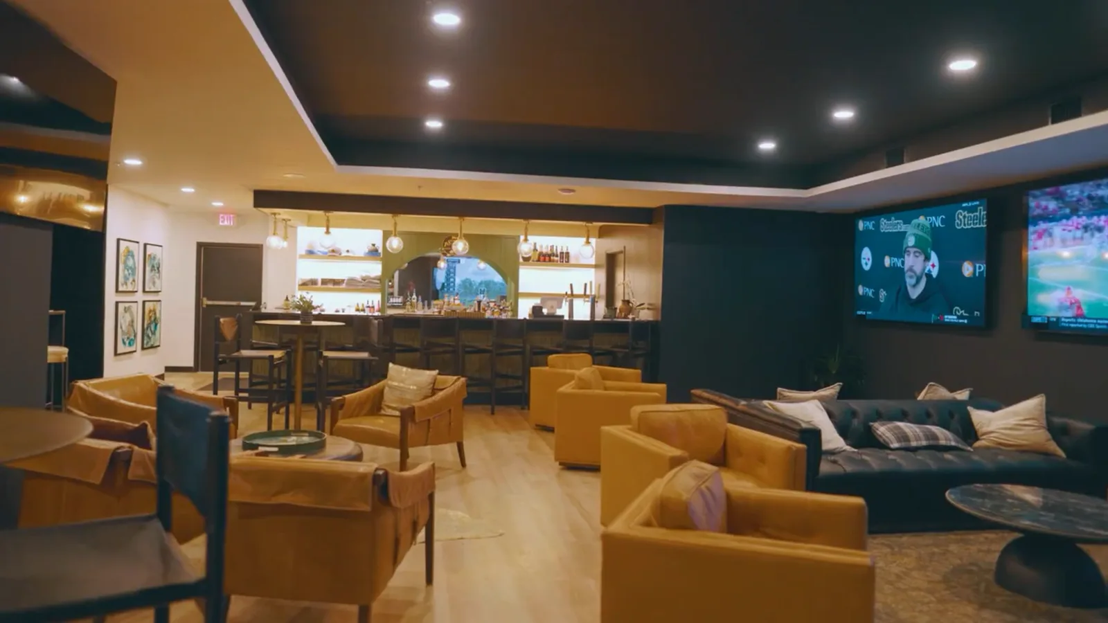 Members lounge with leather seating and sports on the TVs at 1872 Golf Club