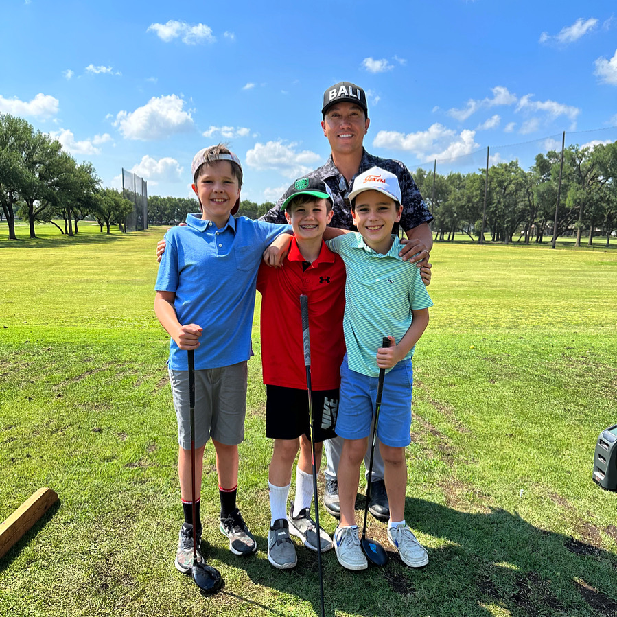 Coach Francis with three young junior golfers on the practice range