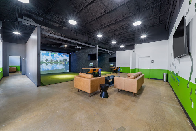 The Back Nine East Austin — indoor golf simulator lounge with leather sofas, hitting bays, and putting green on Airport Blvd