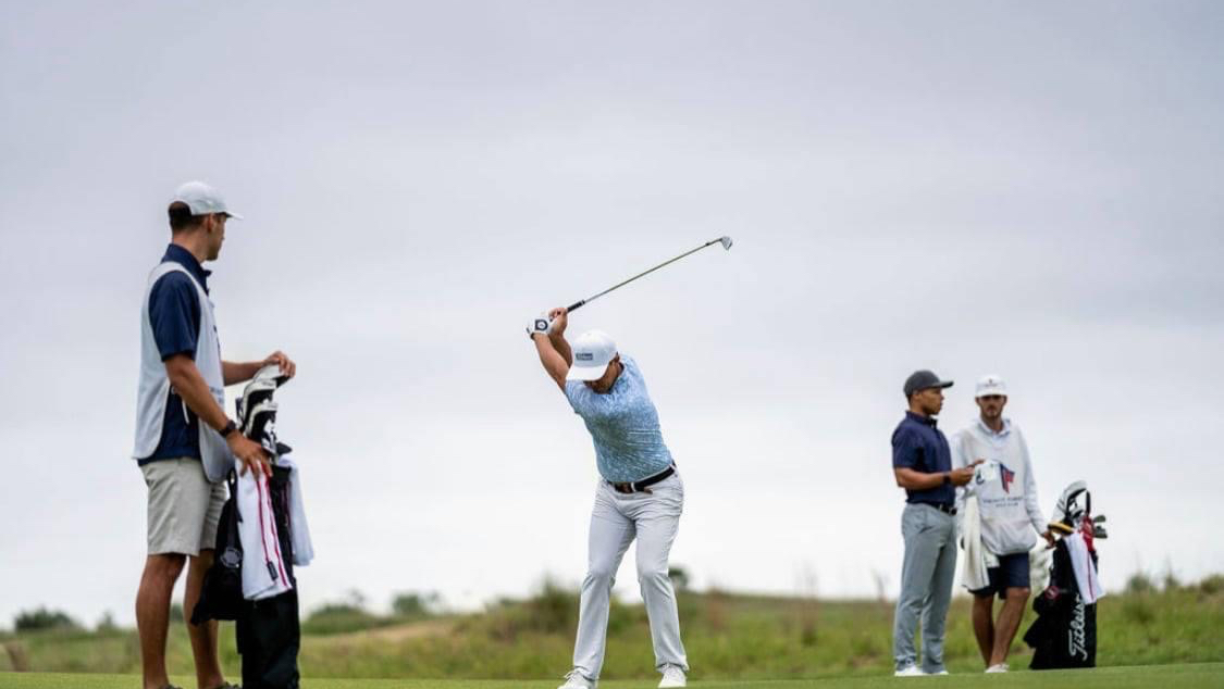 Golf coach guiding a student through a repeatable pre-shot routine on the range